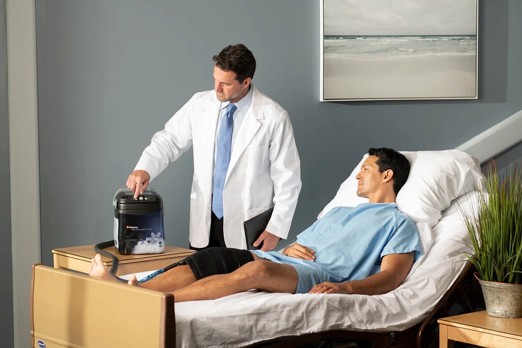 Doctor preparando equipo Breg Polar Care Wave para paciente en hospital
